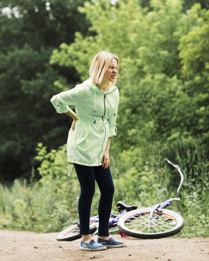 frau-mit-ruckenschmerzen-und-fahrrad-gefallen